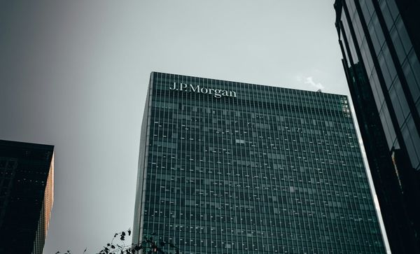 JPMorgan Chase headquarters exterior with financial market data visuals.