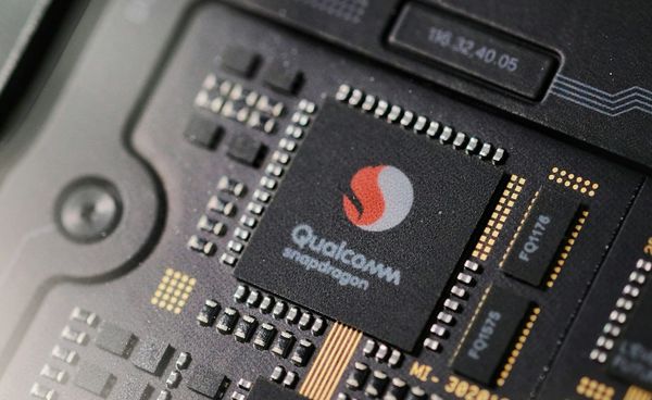 Smartphone processor chip with AI circuitry representing Qualcomm growth and rising competition for Apple in the AI device market