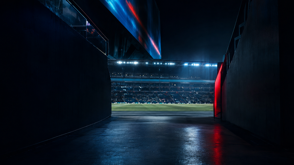 Stadium tunnel opening onto a lit football field