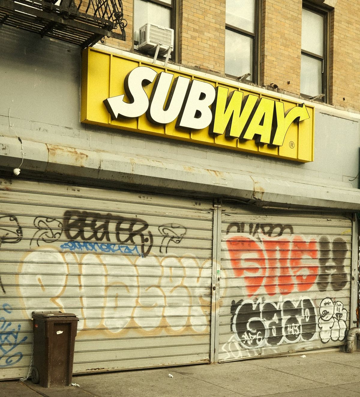 An urban Subway franchise, covered in graffiti