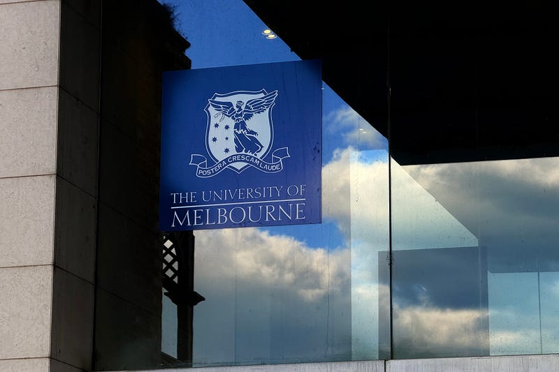 Photo of a building sign with the University of Melbourne logo.