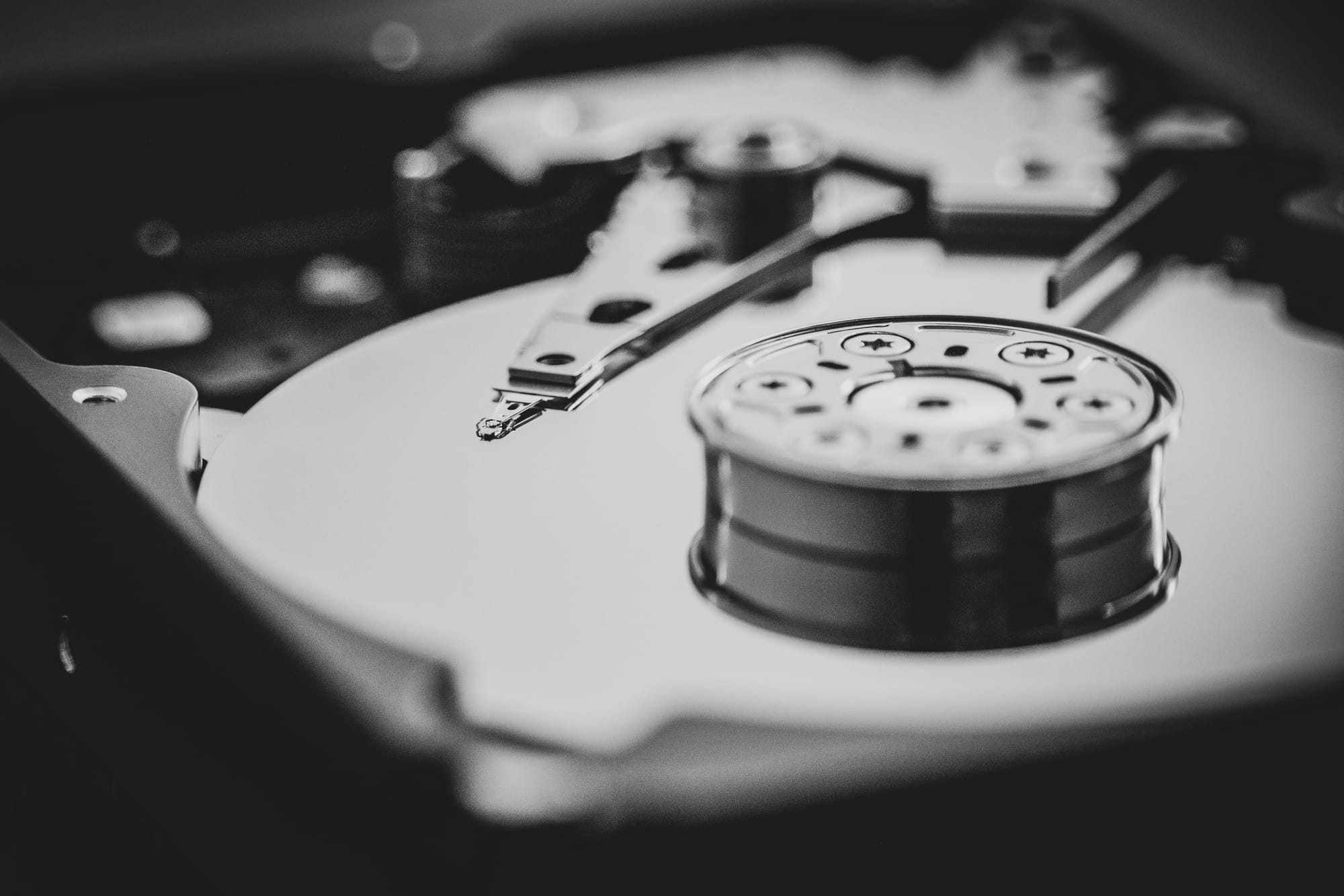 A black and white photo close up of the mechanism inside a hard drive. 