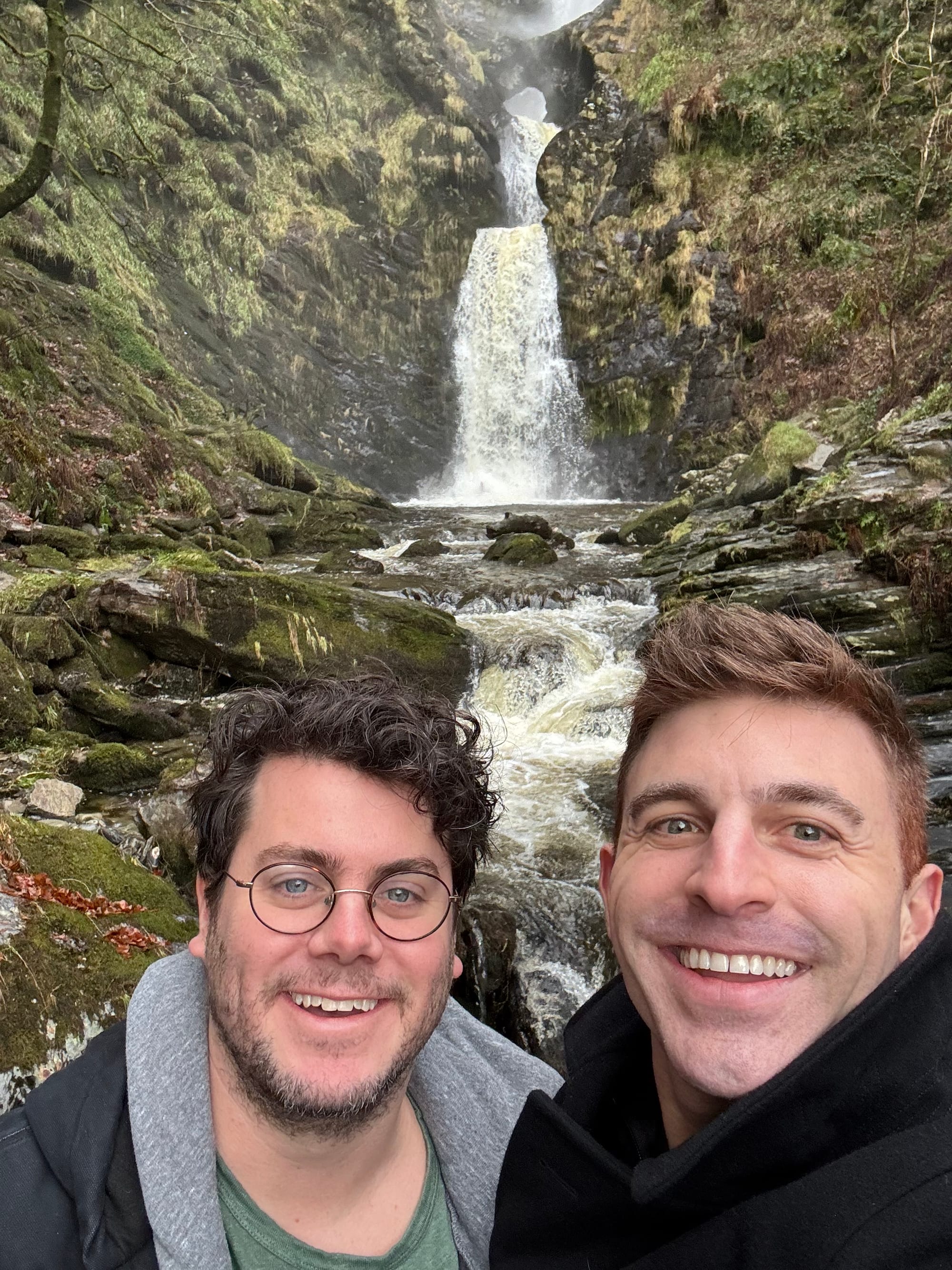 A selfie of me and Justin in front of a crazy beautiful waterfall that honestly looks fake
