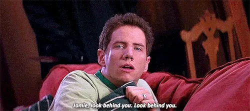 Gif of Jamie Kennedy in Scream yelling "Jamie, look behind you" while ghostface walks up behind him.