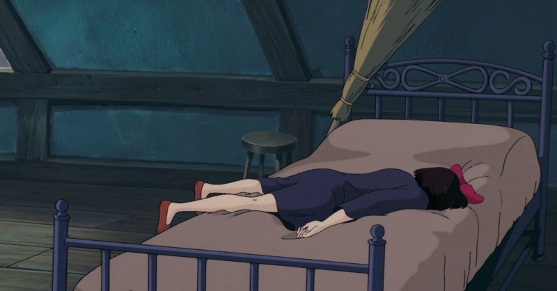 Still from Kiki's Delivery Service showing Kiki face down on her bed