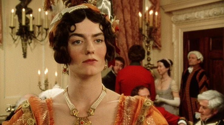 Anna Chancellor looking haughty in orange at a party, screenshot from Pride & Prejudice (1995