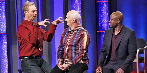 Ryan Stiles, Colin Mochrie, and Wayne Brady in Whose Line Is It Anyway. Ryan appears to be imitating a dinosaur.