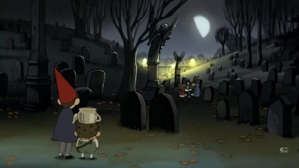 Two small boys, one with a red pointy had, one with a kettle on his head, survey a graveyard.