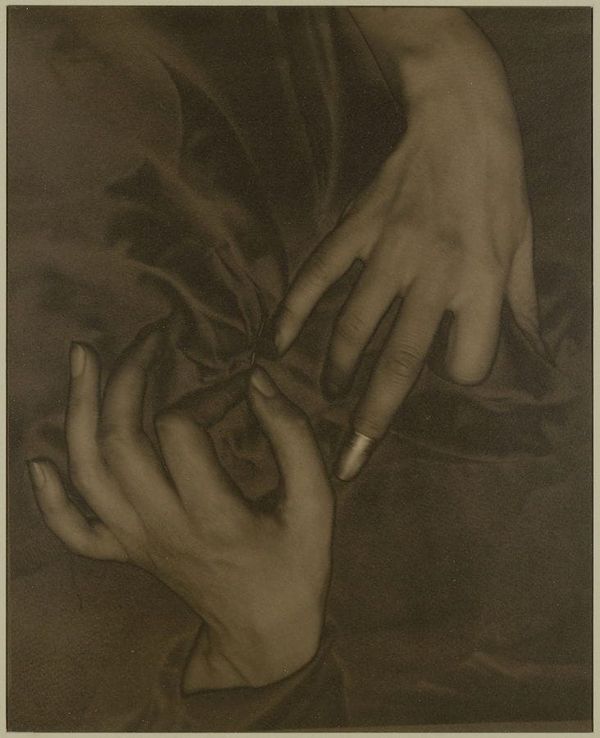 Sepia photograph of a woman's hands in fabric, with a thimble on one index finger