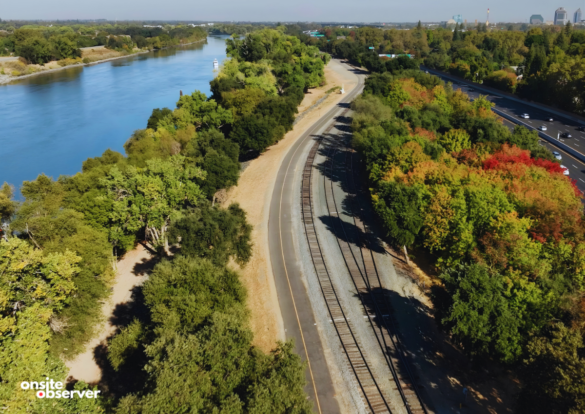 A section of the Sacramento River Bike Trail runs alongside railroad tracks and the Sacramento River near Land Park