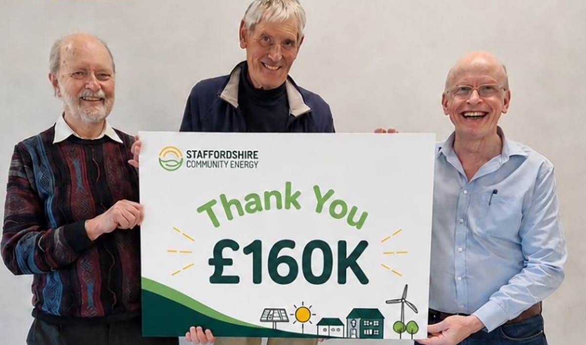 Three men holding a 'thank you £160k' Staffordshire Community Energy sign