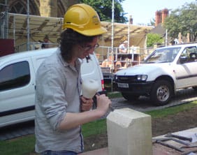 A visitor learns the art of being a stone mason