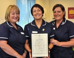 Julie Anne Hughes shows her award to colleagues