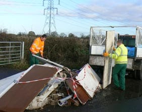 Workers clean up the dumped rubbish