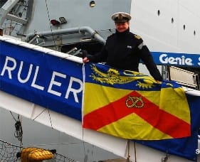 Captain Shaun Jones takes the Staffordshire Flag aboard RFA Wave Ruler
