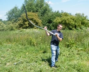 A volunteer using a scythe at Christian Fields in Lichfield