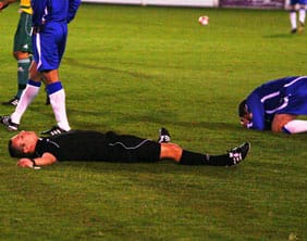 double-knockdown Referee Rob Smith and Chasetown's Gavin Saunders after their clash of heads. Pic: Dave Birt
