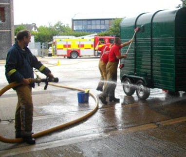 Firefighters cleaning a horse box