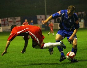 Chasetown's Dean Perrow is bundled off the ball. Pic: Dave Birt