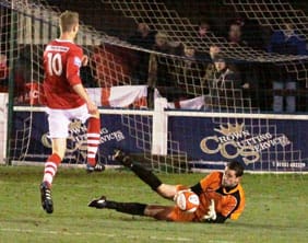 Chasetown's Ryan Price saves at the feet of a Workington striker. Pic: Dave Birt
