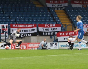 Matthew Wolfenden puts the ball past Ryan Price. Pic: Dave Birt