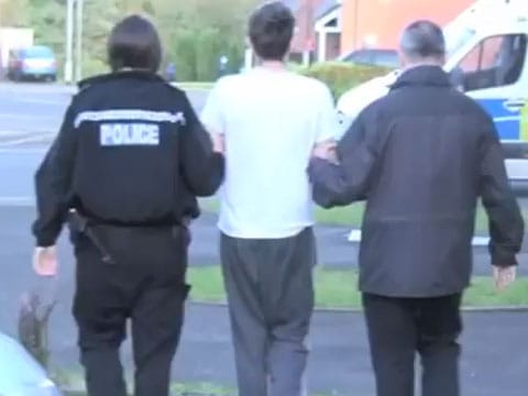 A man being led away during the raids