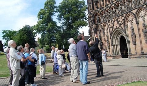 A guided tour group outside Lichfield Cathedral