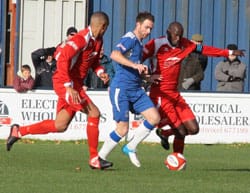 Nick Wellecomme is squeezed out by two Rushall players. Pic: Dave Birt