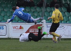 Alex Mallong saves at the feet of Nick Wellecomme. Pic: Dave Birt