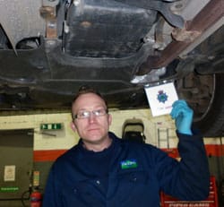 Service technician Mark Pucci at the catalytic converter marking event