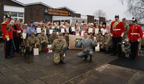 The knitted beanie hats are handed over outside The Staffordshire Regiment Museum