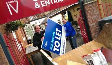 Russell Tomlinson and Julie Brickett get rid of the To Let sign at the George IV pub