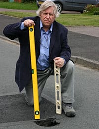 Cllr Steve Norman next to the 3ft-deep pothole