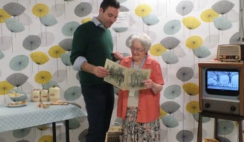 Richard Ernest, managing director of RemPods, looking at a 1950s magazine with hospital volunteer Brenda Bartram