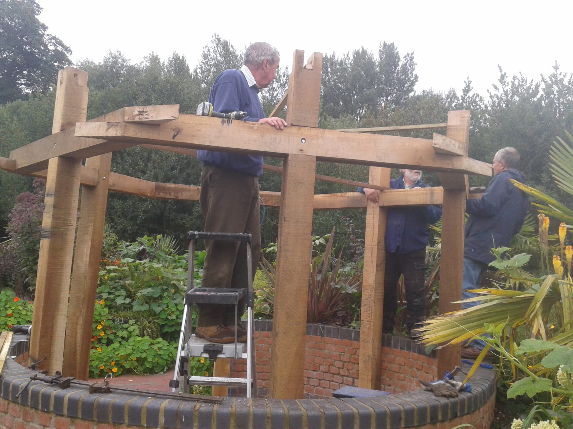 Dave Watton and Steve Eley building a covered seating area in the walled garden