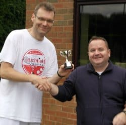 James Roberts picking up the Racketlon Championship trophy from Mark Wilkinson