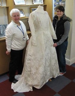 Museum volunteer Carole Griffiths shows visitor Sarah Lampet-Wood a 1960s wedding dress which will feature in the new exhibition