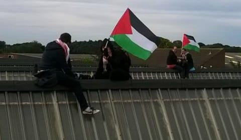 Protesters waving Palestinian flags on the roof. Pic: London Palestine Action