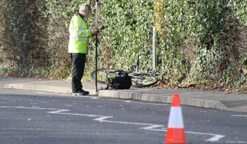 Police investigators examine a bike after a crash in Streethay