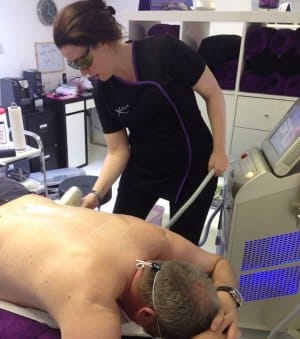 A male Xodos client having a back treatment