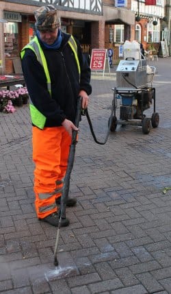 A street cleaner working to remove gum from Lichfield's streets