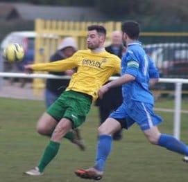 Former Lichfield man Jon Huckfield clears under pressure from Liam Holt