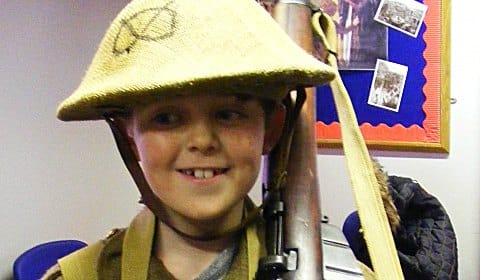 A young visitor trying on uniforms at the Staffordshire Regiment Museum