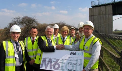 The donation is handed over in the shadow of the aqueduct over the M6 Toll