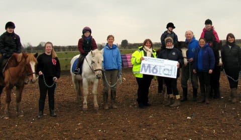 The cheque is handed over to riders and volunteers at Lichfield Riding for the Disabled