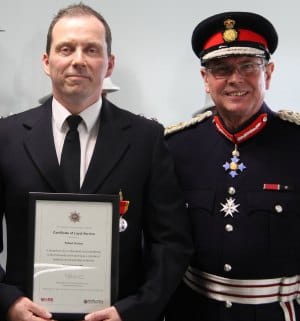 Rob Horton receiving his certificate and medal from the Lord Lieutenant, Ian Dudson