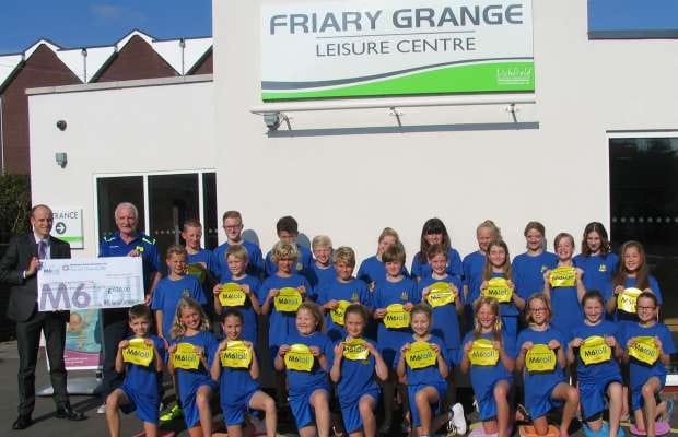 Members of Lichfield Swimming Club receive their new kit from Midland Expressway Ltd