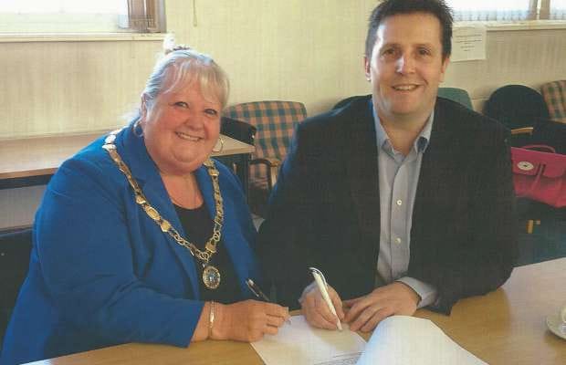 Burntwood Town Council chair Pam Stokes and leader Richard Mosson signing the lease on the Old Mining College Centre