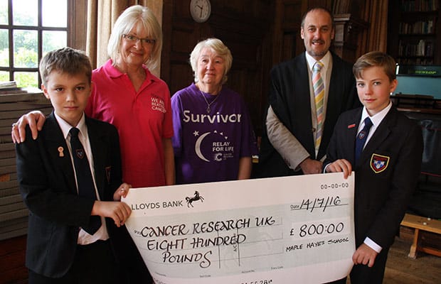 Pupils Daniel Streeter and Jake Flood hand over the cheque to Lorraine Moore and Pauline Colingswood with headteacher Dr Daryl Brown