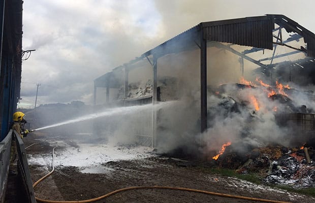 A firefighter dousing the flames in a barn at Yoxall
